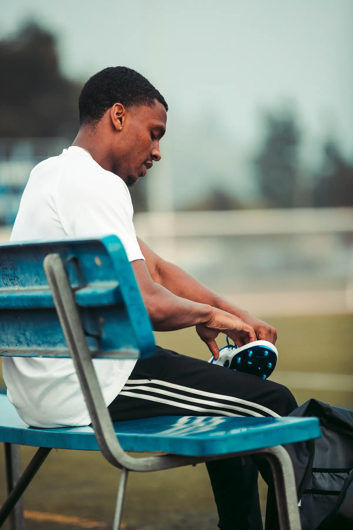 Athlete lacing up on the bench before a take