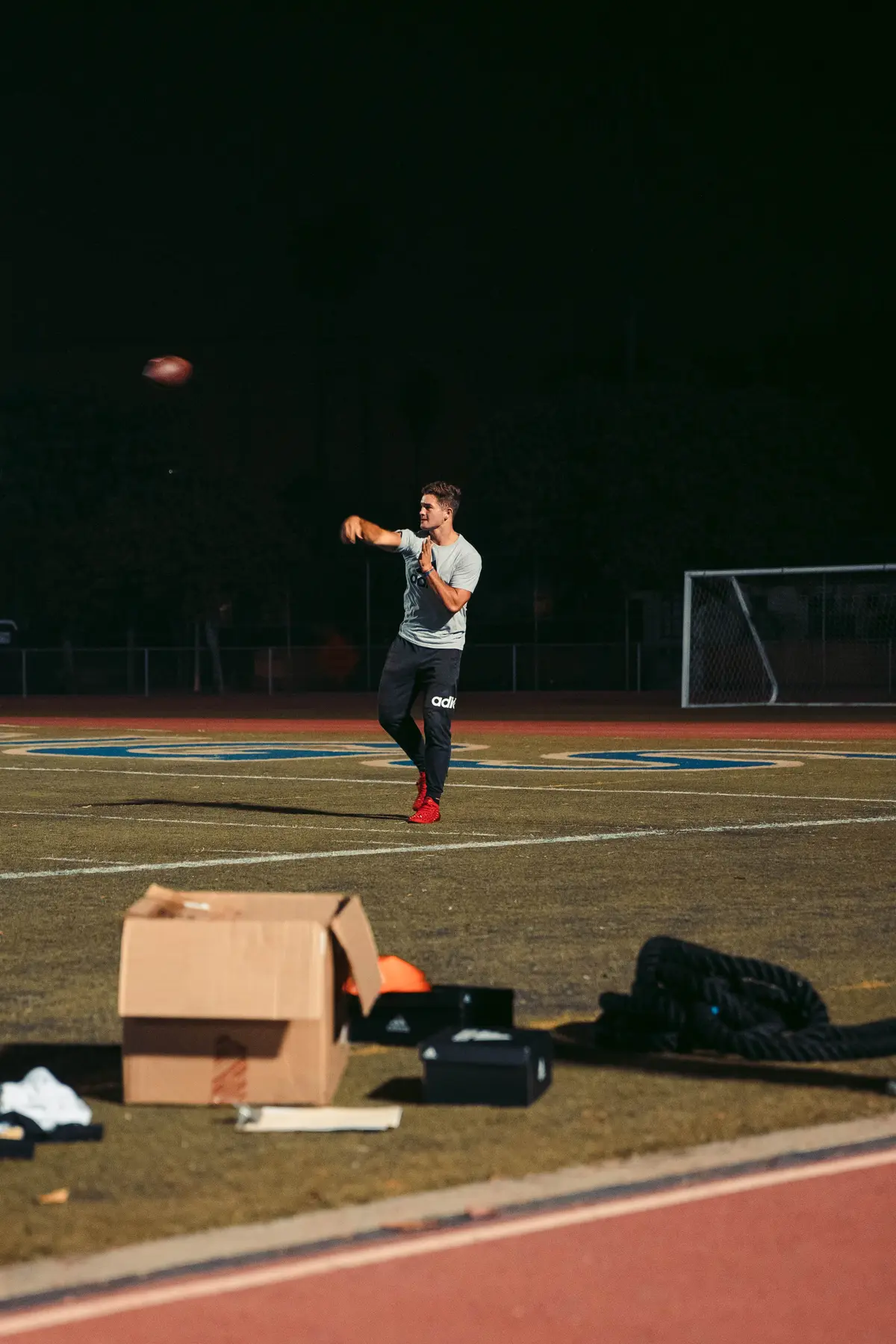 Athlete throwing under the lights on the darkened field