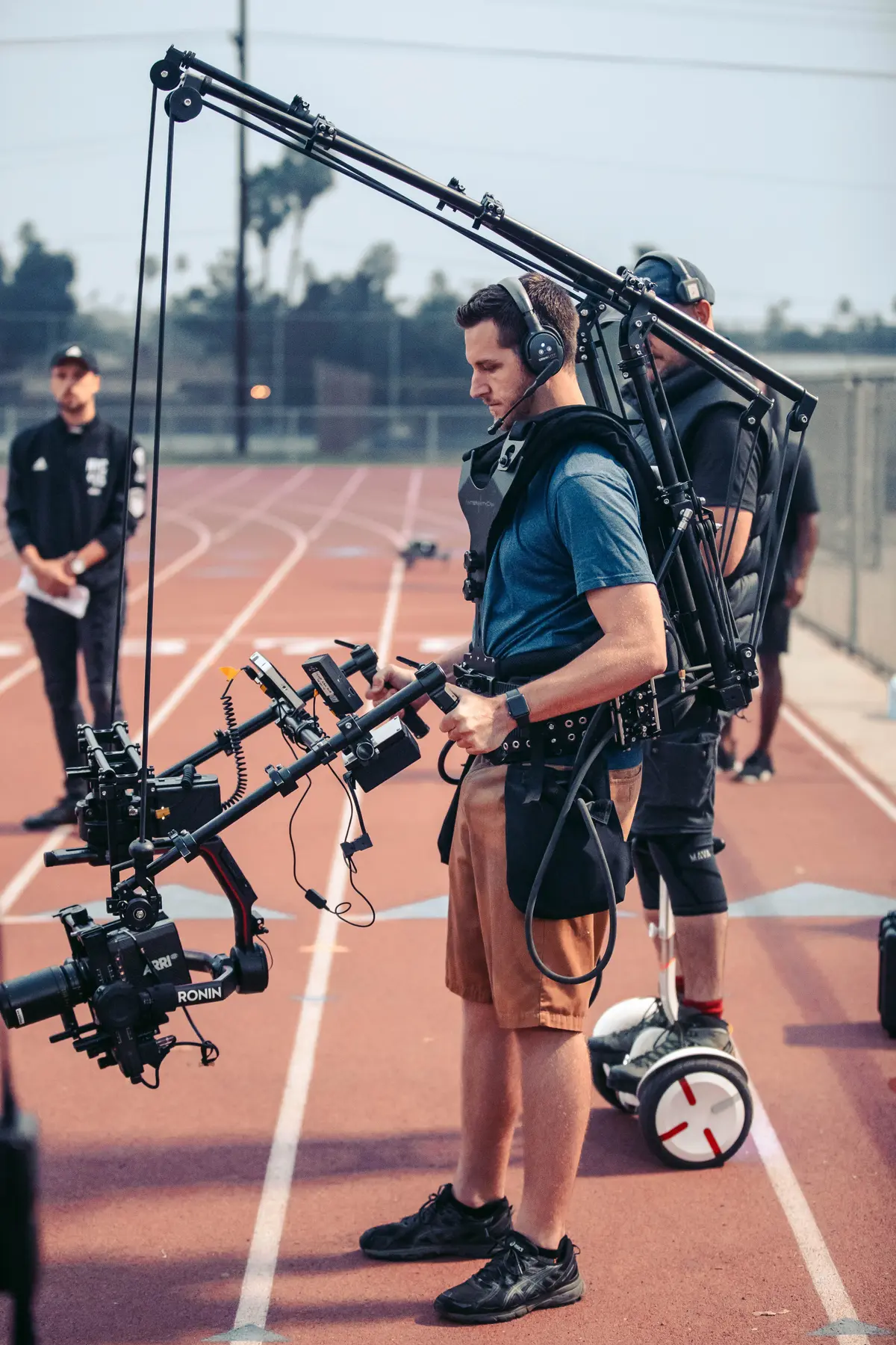 Crew running a jib rig along the running track at night