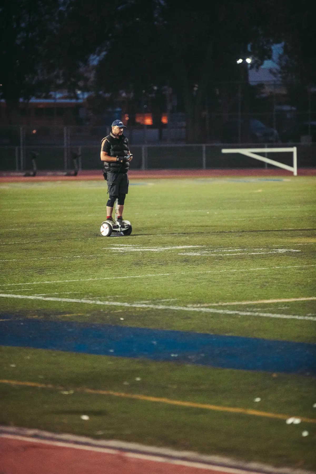Lone operator crossing the field beneath the goalposts