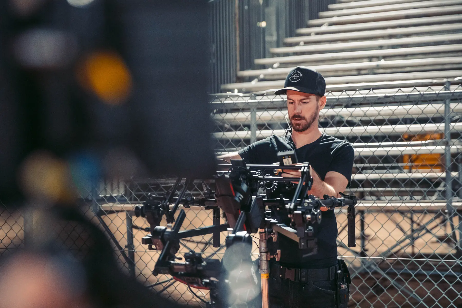 Operator working a gimbal rig in front of the bleachers