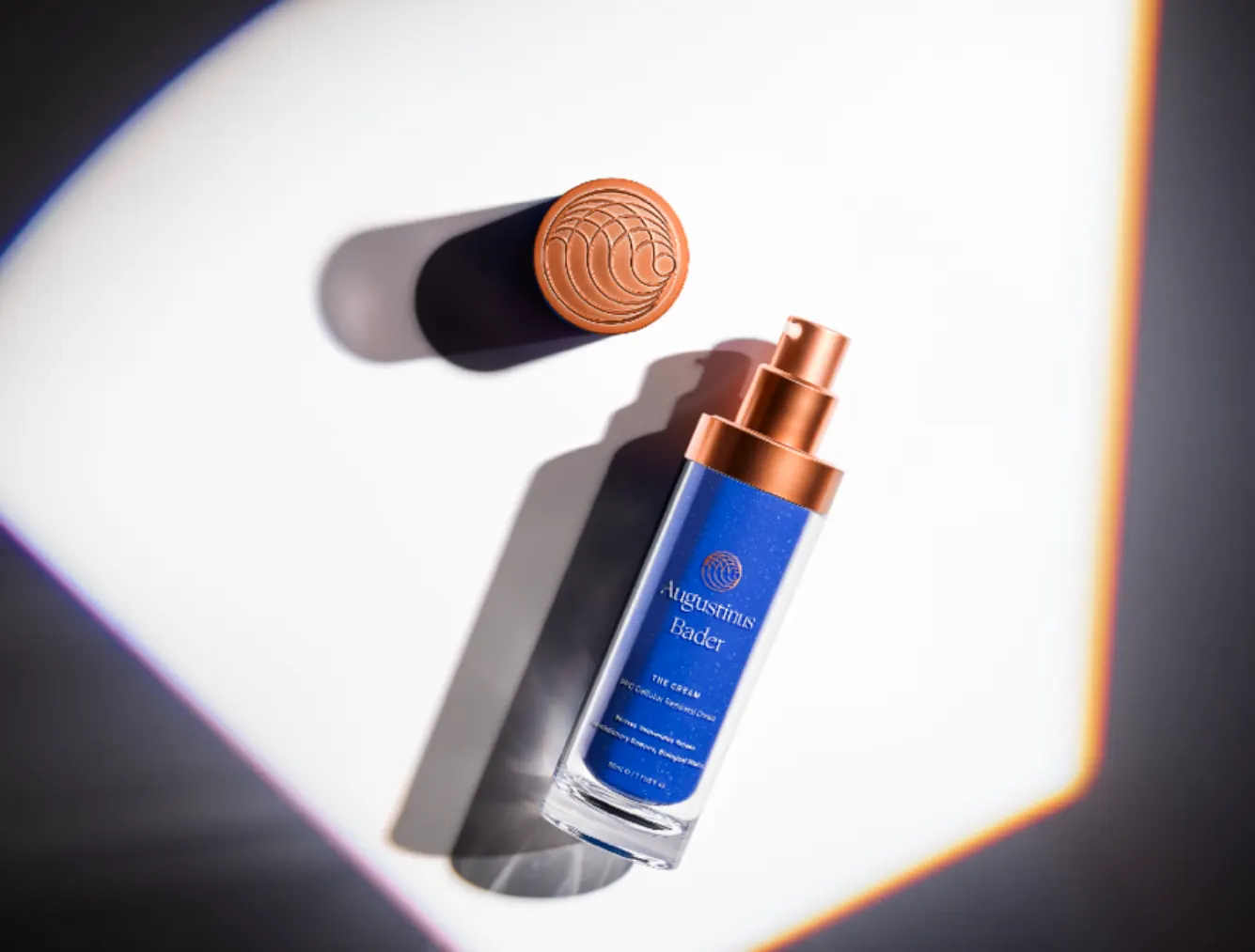 The Cream bottle and copper cap under hard light with a prism flare